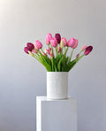 Tuesdays: blush, pink and plum tulips in an embossed white vase on a white plinth